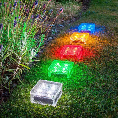 Multicolored Ice Cube Solar Glass Brick Path Lights 4 Pack For Garden And Yard, illuminating a garden path at night.