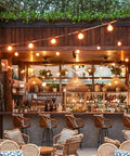 Outdoor String Lights 25 Feet G40 Globe Bulbs With 27 Edison Glass Bulbs Plus 2 Spares illuminating a cozy patio bar setup.