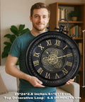 24 Inch Moving Gear Wall Clock Oversized Industrial Steampunk Decor With Big Numerals Carbon Black Finish, held by a person.
