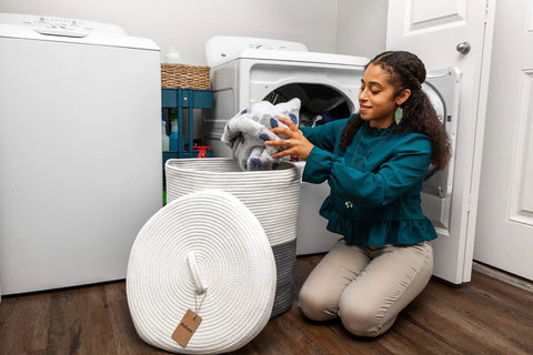Woman using Large Laundry Basket With Lid Tall Woven Cotton Hamper For Blankets Clothes Toys Pillows Towels And Baby Nursery Essentials in laundry room
