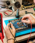 Person using digital multimeter from All In One Soldering Kit With 60W Adjustable Iron, 30 In One Tips, 110V US Plug while working on circuit board.