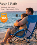 Father and son sitting on Low Profile Folding Beach Chair With Cup Holders And Carry Bag at sunset on beach, highlighting stability.