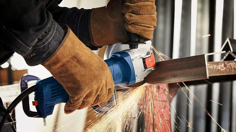 Built Different Five Inch Angle Grinder crunches concrete and metal up to 11500 RPM while cutting steel with sparks flying.