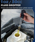 Hand using 1oz fluid dropper to remove brake fluid from master cylinder reservoir in vehicle