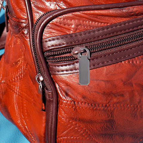 Heavy Duty Metal Zipper Pull Tabs Replacement Set With Super Straightforward Tool Free Install For Jacket Fixes Clothing Repairs And Gear Upgrades In A Compact 12 Piece Pack That Gives You Zero Sweat Quick Repairs Every Single Time on an orange leather bag.