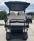 High Capacity Six Passenger Electric Golf Cart Featuring Rear Flip Seats Quiet Motor Drive Plush Padded Upholstery And Built In Armrests rear view with plush seats.