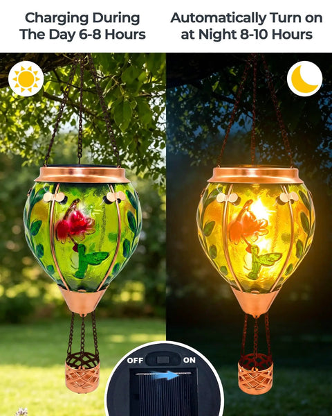 Glass Hot Air Balloon Solar Lantern With Flame Hand Painted Artwork Realistic Flickering Flame Hummingbird Accent Rustproof Metal Outdoor Solar Light For Garden Or Yard Easy Setup And Eco Friendly, showing day and night operation.