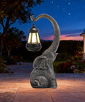 Outdoor Solar Powered Elephant Garden Statue With LED Lantern Lights, waterproof resin yard decor glowing in evening garden.
