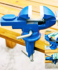 Mini Home Clamp-On Vise With Nylon Jaws, 2-Inch Jaw, 2.2-Inch Opening, Lightweight 1470g, The Go-To Tool For Electronics, Jewelry, Hobby, Model Making And Small Bench Projects. blue clamp-on vise on a wooden bench