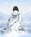 Person wrapped in Mylar Emergency Blankets Space Blanket Thermal Survival Gear in snowy outdoors.