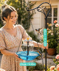 Woman setting up Solar Hanging Bird Bath Fountain With Cascading Water Effect For Garden Patio And Backyard Outdoor Solar Powered Bird Bath Fountain Easy No Fuss Setup Low Maintenance Water Display in garden.