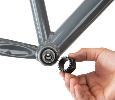 Hand holding Bottom Bracket Tool BBT-32 for 20-Tooth Splined Cups Shimano and Drive near bicycle frame