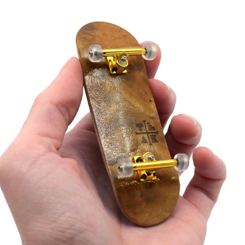Hand holding 32mm Pro Fingerboard Complete Set with Pro Shaped Wooden Deck 32x97mm, UltraSpin Bearing Wheels, ready to ride.