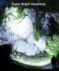 Rechargeable LED Headlamp Beast Bright With Three Light Modes illuminating rocky landscape at night.