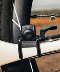 Close-up of Padrone Digital Bluetooth Cycling Computer With IPX8 Waterproof Build attached to a bike frame near the rear wheel.