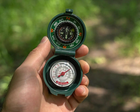 Trail Ready Compact Hiking Compass With Thermometer for Camping and Outdoor Navigation held in hand on trail