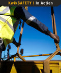 KwikSafety Mighty Sumo 1x8 ft poly web lifting sling in side view, used by worker in hi-vis jacket and gloves.