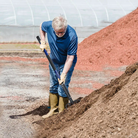 Man using Five-Tine Pitchfork For Gardening 57-Inch Heavy Duty Garden Fork With Fiberglass Handle For Mulch Compost Manure Hay And Soil Loosening Blue Built For Tough Jobs.