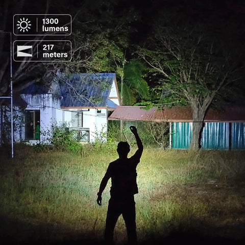 Tiny But Mighty EDC Flashlight Rechargeable 1300 Lumens illuminating a backyard at night, showing 217 meters beam reach.