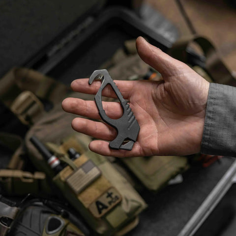 Person holding Pocket Size Seatbelt Cutter Escape Tool With Lanyard Hole And Glass Breaker One Hand Deployment 420HC Steel Hook Knife