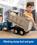 Child playing with Blue Peterbilt 1/16 Scale Dump Truck Toy With Working Dump Bed 20 Inch Construction Vehicle indoors.