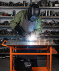 Worker using Rugged 36 Inch By 24 Inch Welding Table With 800 Pound Capacity Portable Welding Workbench On Wheels in garage workshop