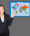 Woman pointing at Kid Friendly World Map from Three Poster Pack Laminated 18 by 24 Inch USA Map for Kids, Periodic Table Set