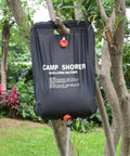 Large Capacity Solar Shower Bag 5 Gallons 20L for Camping Outdoors hanging on a tree with hose