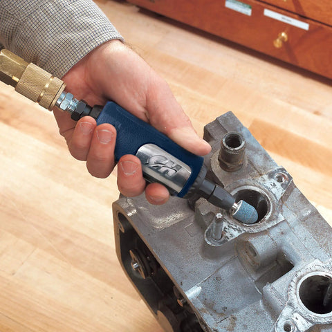 Rugged 1/4 Inch Pneumatic Die Grinder Packing Hella Fast 25000 RPM Power in use for deburring metal engine part.