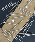 Zero Drama 120 Pack Of 2 Inch Nickel Plated Rust Proof Carbon Steel Hardware Nails scattered on wood.
