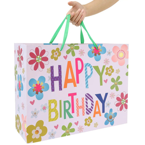 Sixteen Point Five Inch Extra Large Colorful Happy Birthday Gift Bag Set With Handles showing floral design, held by hand