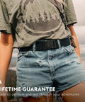 Original Unisex Adventure Belt With Heavy Duty Elastic Webbing And Non Metal Travel Buckle For Active Lifestyles Medium Brown worn outside