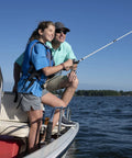 Two people fishing on a boat with Portable 12 Gallon Marine Gas Can under seat, lake in background