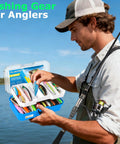 Man holding Telescopic Fishing Rod And Reel Combo with 373 Piece Tackle Box by the lake, examining lures in sunlight.