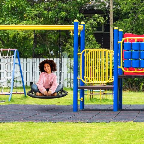 Child sitting on Saucer Tree Swing For Kids, 24 Inch Net Seat Disc Round Swing, in colorful playground setting
