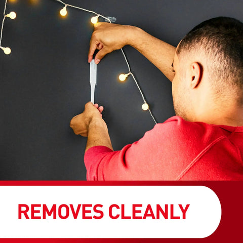 Person demonstrating Medium Wire Hooks Set With 3 Hooks And 4 Strips Damage Free Wall Hangers With Adhesive Strips next to lights