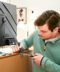 Man installing Universal TV Security Straps Four Pack For Wall Furniture And Anti Tip Configurations Secure Your TV To The Wall Or Furniture