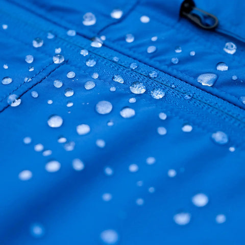 Water beading on blue fabric treated with Revivex DWR Spray For Waterproof Jackets And Rain Gear Keeps Your Gear Dry And Gore-Tex Breathable