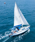Sailboat navigating on open sea under blue sky