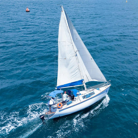 Sailboat navigating on open sea under blue sky