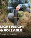 Person packing Reusable Self Healing Rubber Archery Target Face Roll Up Practice Target Sheet into a bag, outdoors.