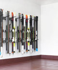 Modern Top Shelf Heavy Duty Wall Mount Ski Rack Solid Garage Game Changer To Securely Hold 16 Pairs Of Long And Short Alpine Skis Plus Snowboards With Hook Clamps mounted with skis on a white wall.