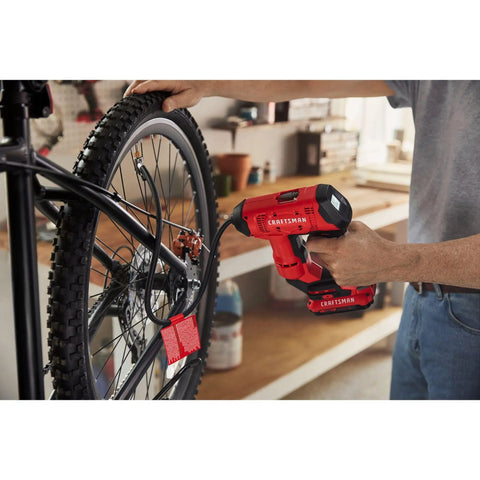 Person using V20 Cordless Tire Inflator And Portable Air Compressor With Digital Pressure Gauge Up To 150 Psi on a bicycle tire