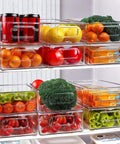 Stackable Fridge Organizer Bins Set Of 6 Clear Kitchen Storage Bins With Easy Grip Handles Includes 20 Plastic Bags For Pantry Cabinets Shelves Drawers And Freezer Food Safe BPA Free 10 Inch Long filled with fruits and cans in a fridge