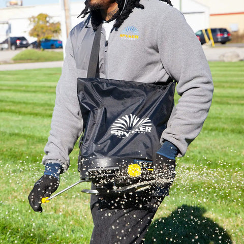 Person using Spyker 25Lb Bag Spreader With Material Viewing Window And Easy Calibration System Built For The Lawn And Farm On The Job