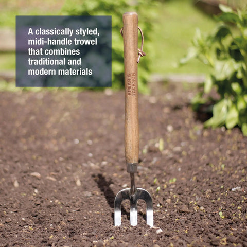 Stainless Steel Hand Weeder Fork For Easy Weeding And Soil Aeration in garden soil with ergonomic wooden handle