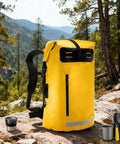 Yellow waterproof hiking backpack with PVC construction, large capacity daypack for outdoor adventures, rucksack style on rocks.