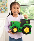 Child holding John Deere Tractor Toys Value Set With Portable Carrying Case For Kids On The Go, toy tractor front view