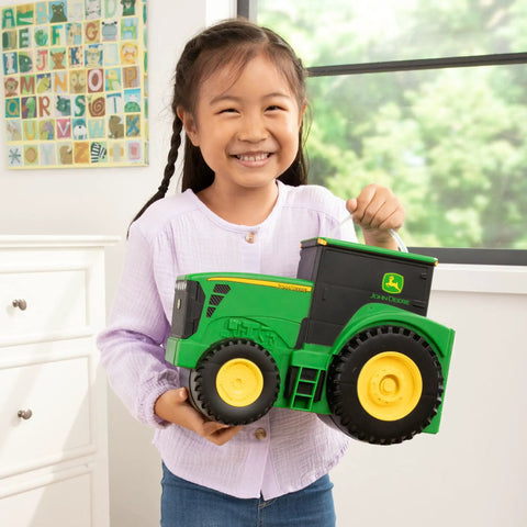 Child holding John Deere Tractor Toys Value Set With Portable Carrying Case For Kids On The Go, toy tractor front view
