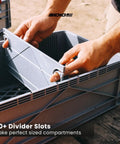 Hands adjusting divider in Heavy Duty Stackable Storage Bins With Standard Dividers Rock Solid Blue Plastic Crates For Garage And Closet.